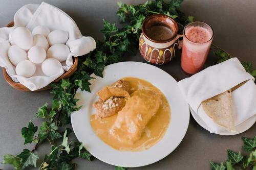 a table with a plate of food with eggs and a drink at Hotel Leon in León