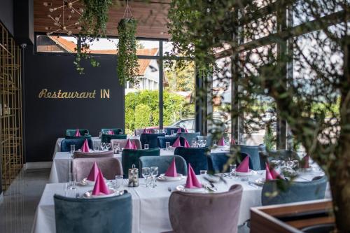 a restaurant with tables with pink napkins on them at Hotel IN in Žepče