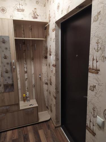 een badkamer met een zwarte deur en een muur met tekeningen bij Элегантная двухкомнатная квартира в центре in Novorossiejsk