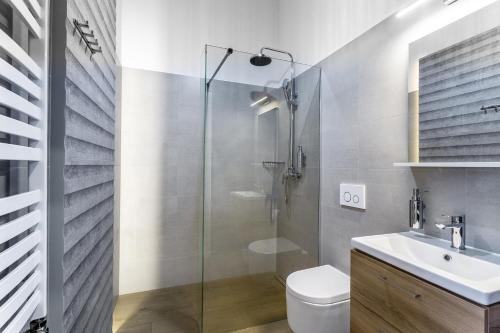 a bathroom with a shower and a toilet and a sink at Apartamenty Nowa Kamienica Częstochowa Centrum Szymanowskiego 22A in Częstochowa