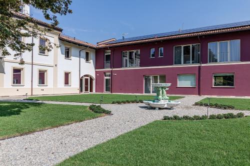 a building with a fountain in the middle of a yard at L'aja della Mirusina - Piedmont Resort Monferrato Langhe in Canelli