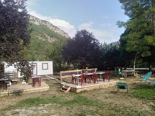 a backyard with a picnic table and a trailer at Camping du lac in Saint-Julien-du-Verdon