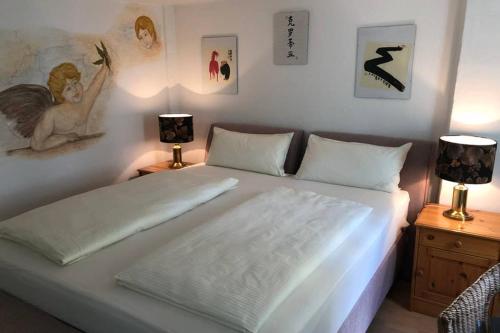 1 dormitorio con 1 cama blanca grande y 2 lámparas en In the Heart of the Island, en Lindau