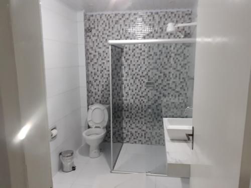 a bathroom with a shower with a toilet and a sink at Sun Valley Hotel in Campo do Meio