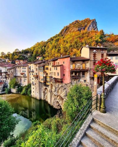 une ville avec un pont sur une rivière et des bâtiments dans l'établissement CoeurAccords, spa & bien-être au calme NATURISTE toute l'année, à Saint-Bardoux