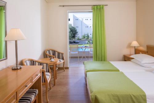 アテネにあるCivitel Attik Rooms & Suitesのベッド、デスク、窓が備わるホテルルームです。