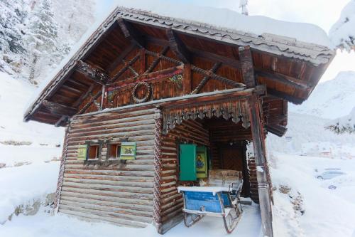 a log cabin in the snow with a blue table at Alpina Residence in Solda