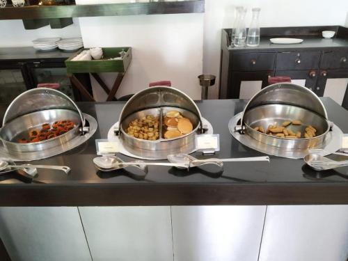 three pans of food on a counter in a kitchen at The Palms Town & Country Club - Resort in Gurgaon