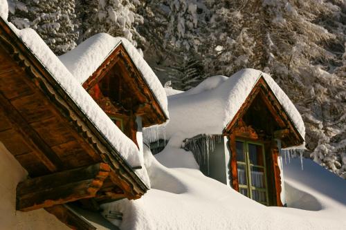 a snow covered cabin with snow on the roofs at Alpina Residence in Solda