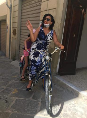 a woman in a dress riding a bike at Vasari Home in Arezzo