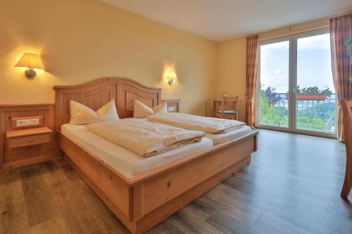 a bedroom with a large bed with a large window at Landgasthof Deutsches Haus KG in Weilheim an der Teck