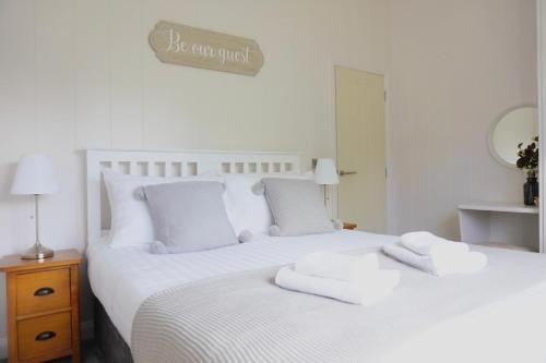 a bedroom with a white bed with towels on it at Linwater Caravan Park - Luxury Lodges and Static Caravans near Edinburgh in Newbridge
