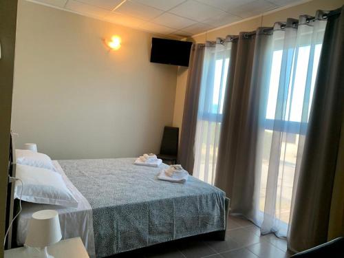 a bedroom with a bed and a large window at LA BUSSOLA in Badia Polesine