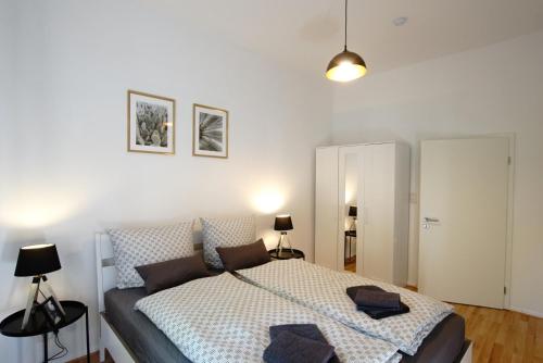 a bedroom with a bed and a white wall at Altstadt-Ferienwohnungen Braunschweig in Braunschweig