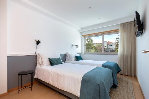 1 dormitorio con 2 camas y ventana en Feel Corporate Housing Marquês, en Oporto