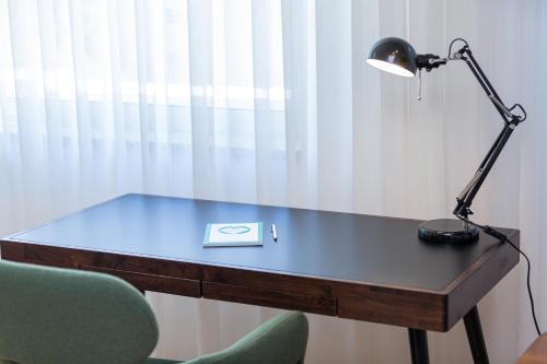 a desk with a lamp and a book on it at Feel Porto Corporate Housing Marquês in Porto