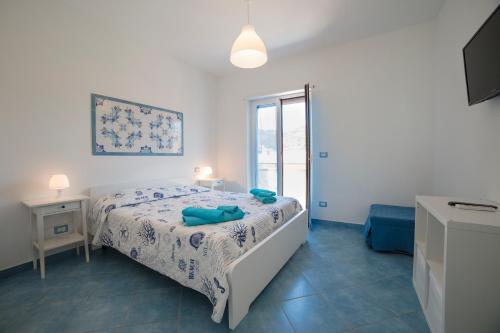 um quarto branco com uma cama e uma janela em B&B Il Capitano em Capo dʼOrlando
