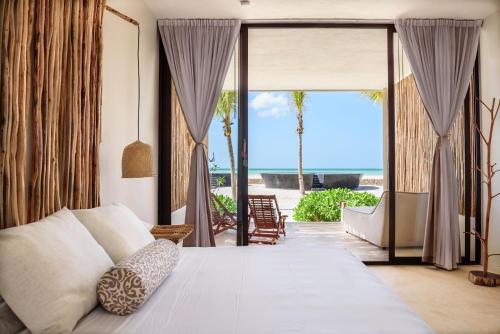 a bedroom with a bed and a view of the ocean at Hotel Villas Flamingos in Holbox Island
