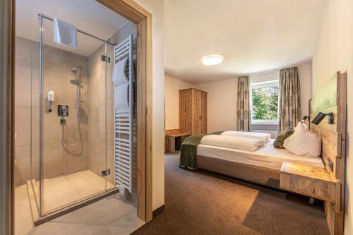 a bedroom with a bed and a glass shower at Home-Hotel Salzberg in Berchtesgaden