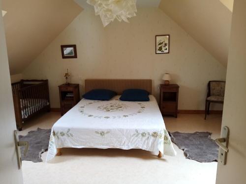een slaapkamer met een bed met blauwe kussens erop bij Gîte à la ferme in Merléac