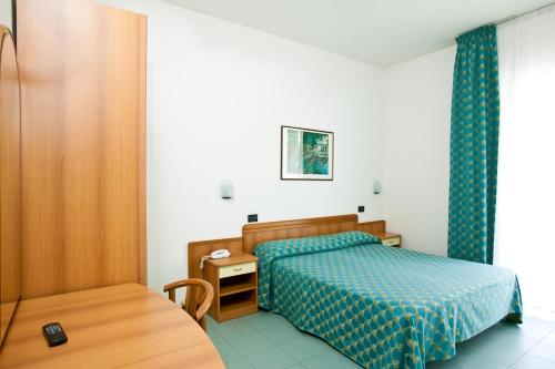 ベッラーリア・イジェア・マリーナにあるHotel Theaの小さなベッドルーム(ベッド1台、テーブル付)