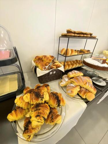 a table topped with plates of pastries and breads at Apulia Praia Hotel in Esposende
