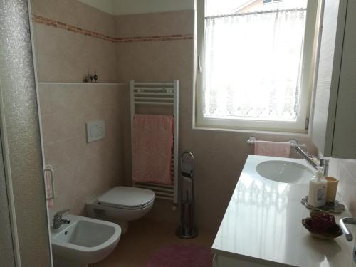 ein Badezimmer mit einem Waschbecken, einem WC und einem Waschbecken in der Unterkunft Ferrarini in Riva del Garda