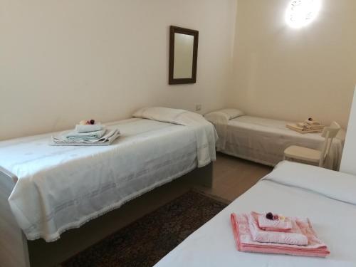 Zimmer mit 2 Betten, Handtüchern und einem Spiegel in der Unterkunft Ferrarini in Riva del Garda