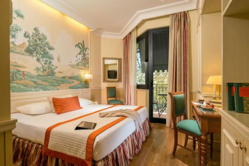 Pokój hotelowy z łóżkiem, biurkiem i oknem w obiekcie Donna Laura Palace by OMNIA hotels w Rzymie
