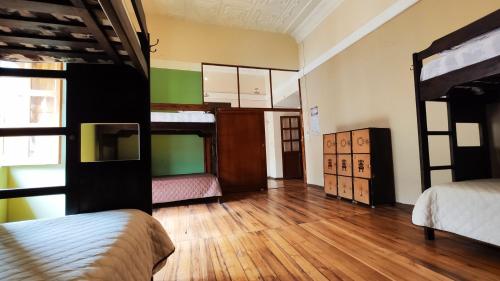 a room with two bunk beds and wooden floors at Hostal Yakumama in Cuenca