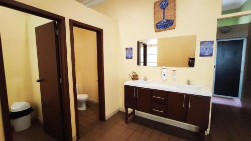 a bathroom with a sink and a toilet and a mirror at Hostal Yakumama in Cuenca