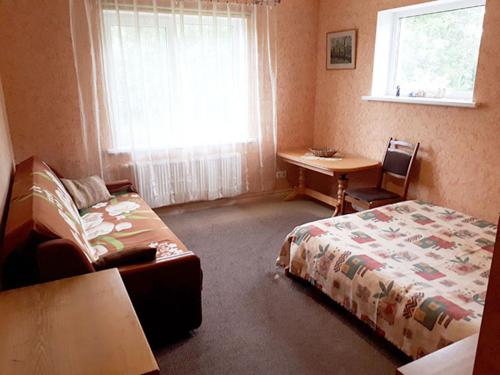 Schlafzimmer mit einem Bett, einem Schreibtisch und einem Fenster in der Unterkunft Svētgravas in Aklaisciems
