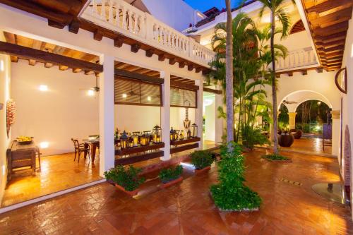 una sala de estar abierta con comedor y una casa en Hotel Quadrifolio, en Cartagena de Indias