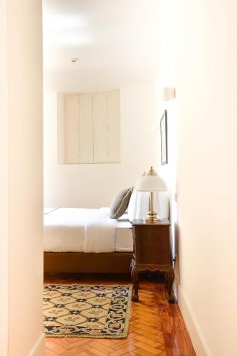 a bedroom with a bed and a table with a lamp at Casa Balthazar in Lisbon
