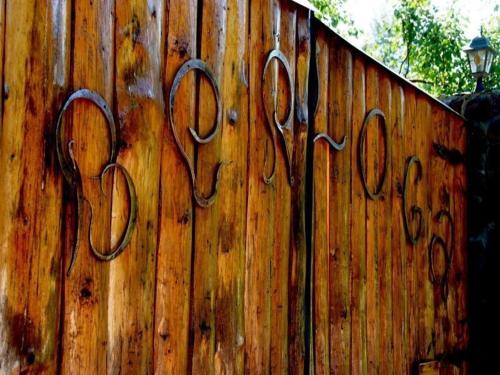 a wooden fence with scissors painted on it at Berloga in Rodnikovka