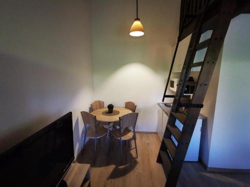 une salle à manger avec une table, des chaises et une échelle dans l'établissement Vali néni kifőzde és apartman, à Kismaros