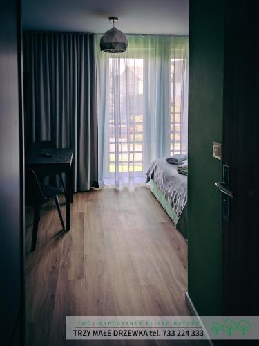a bedroom with a bed and a desk and a window at Trzy Małe Drzewka in Wielka Wieś