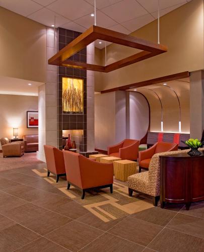 a lobby with orange chairs and a fireplace at Hyatt Place Uncasville - Casino Area in Uncasville