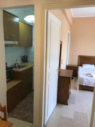 a kitchen with a door leading to a bedroom at Limani Apartments in Kassiopi