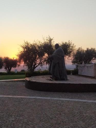 a statue of a man sitting in a park at Pensione Delfino Azzurro in Loreto