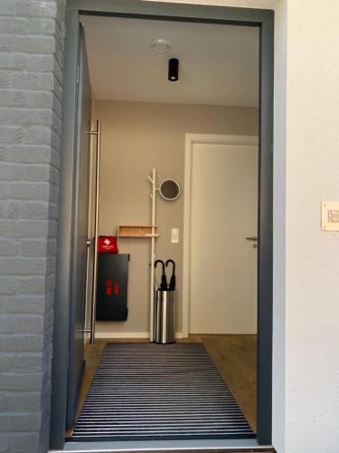 a hallway with a door leading into a room with a rug at Bungalow-Ferienhaus Pottenstein in Pottenstein