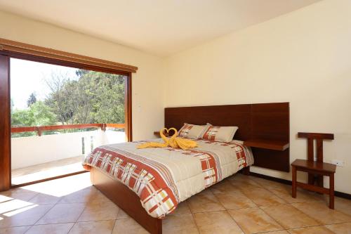 - une chambre avec un lit et une grande fenêtre dans l'établissement Santagua Termas de Chachimbiro, à Urcuquí