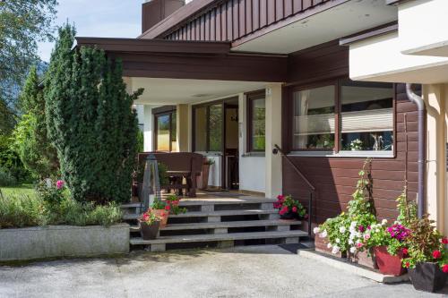 a home with a porch with stairs and flowers at Tirol Appartements Schwaiger in Niederndorf