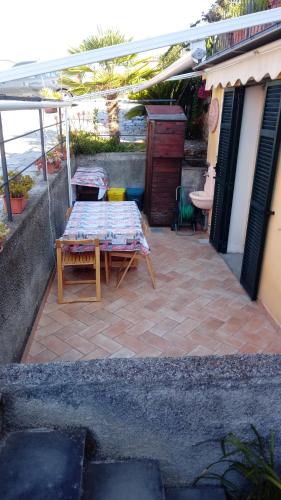 a patio with a table and chairs under an umbrella at Nina House in Imperia