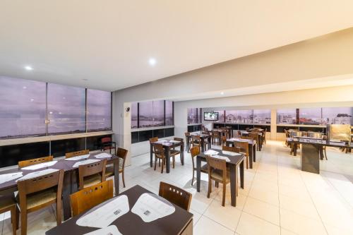 a restaurant with tables and chairs and windows at Rede Andrade Cecomtur in Florianópolis