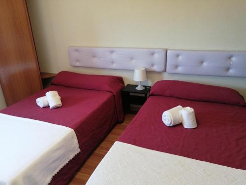 two beds in a room with red sheets and white pillows at Guesthouse RSA by Umbral in Almancil