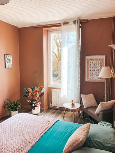 a bedroom with a bed and a window and a couch at chambre salle de bain partagée in Cognac