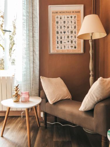 a living room with a couch and a table at chambre salle de bain partagée in Cognac