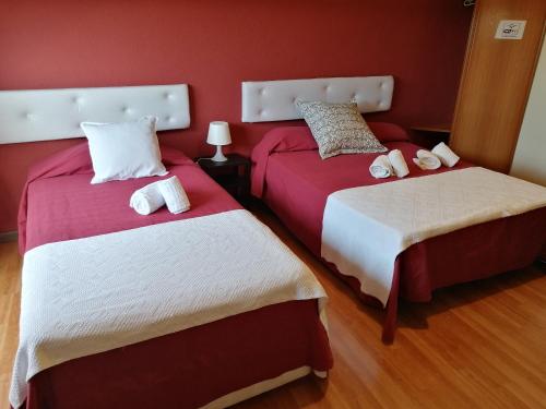 2 letti in una camera con pareti rosse di Guesthouse RSA by Umbral a Almancil