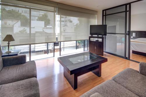 a living room with a couch and a coffee table at Grupo Kings Suites -Platon 436 in Mexico City